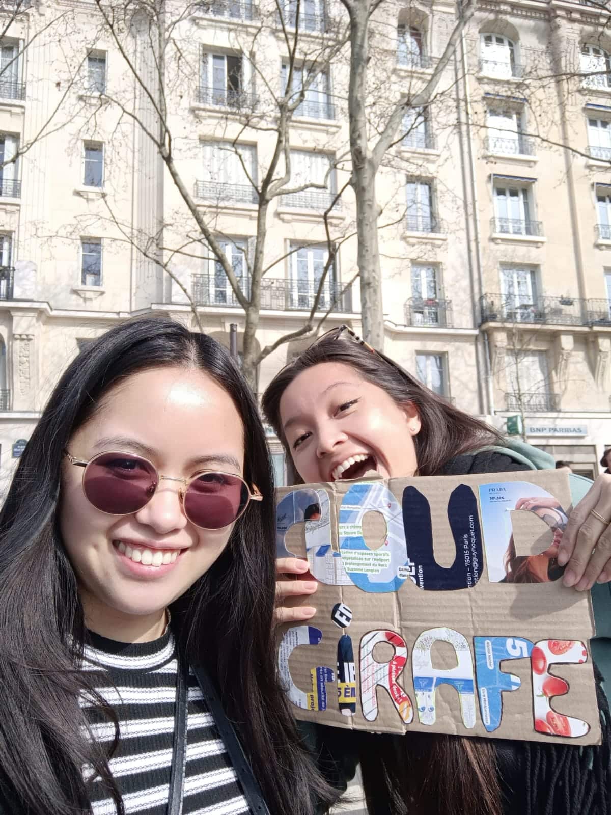 Deux membres de l’équipe Cloud Girafe encouragent les coureurs avec une pancarte pendant le Semi de Paris 2026